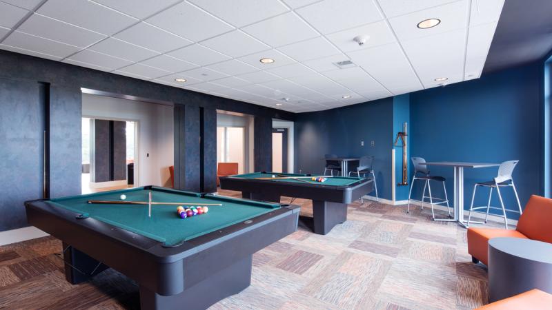 Community room with two pool tables and seating